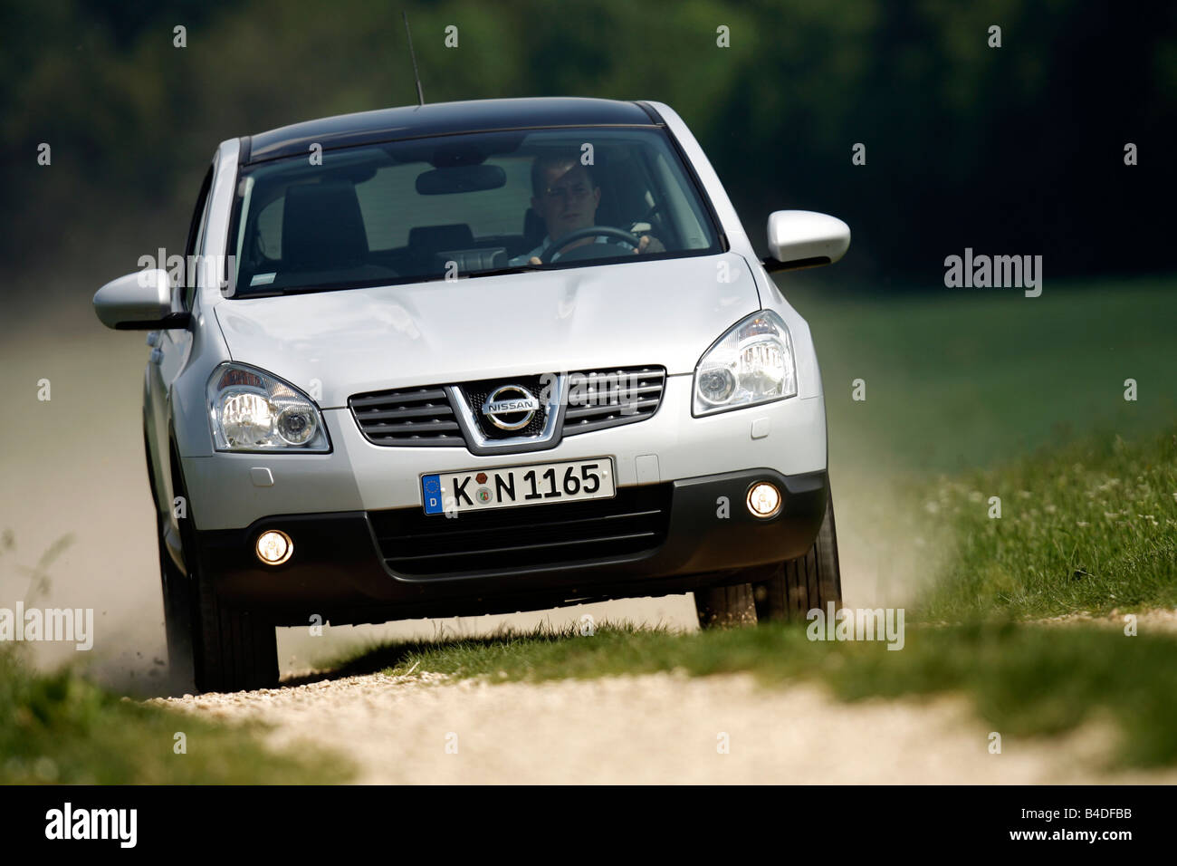 Nissan Qashqai 2.0 4WD tekna, model year 2007-, silver, driving, diagonal from the front, frontal view, Country lane Stock Photo