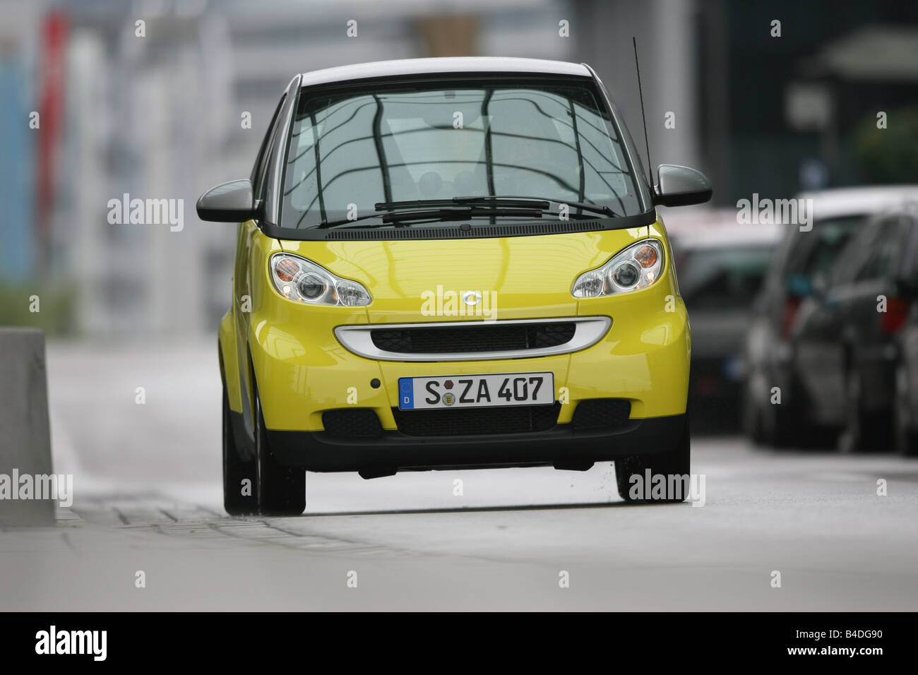Smart Fortwo CDI passion, model year 2007-, yellow, driving, diagonal from the front, frontal view, City Stock Photo