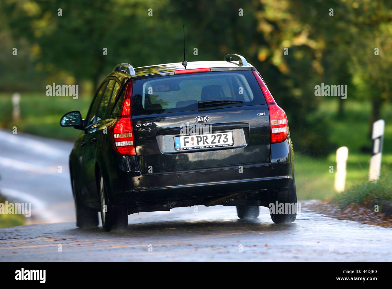 Kia Cee'd Sporty Wagon, model year 2007-, black, driving, diagonal from the back, rear view, country road Stock Photo