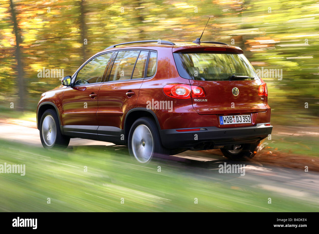 VW Volkswagen Tiguan 1.4 TSI Track & Field, model year 2007-, red, driving, diagonal from the back, rear view, country road Stock Photo