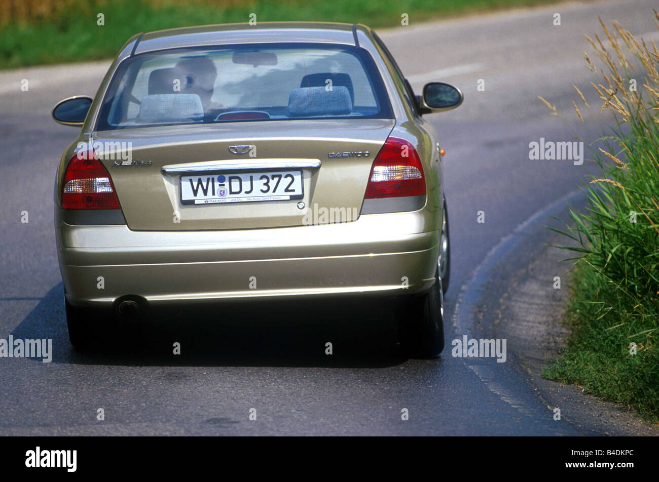 Car, Daewoo Nubira 2.0, Limousine, medium class, model year 1999-, silver-beige, fawn, diagonal from the back, driving, country Stock Photo