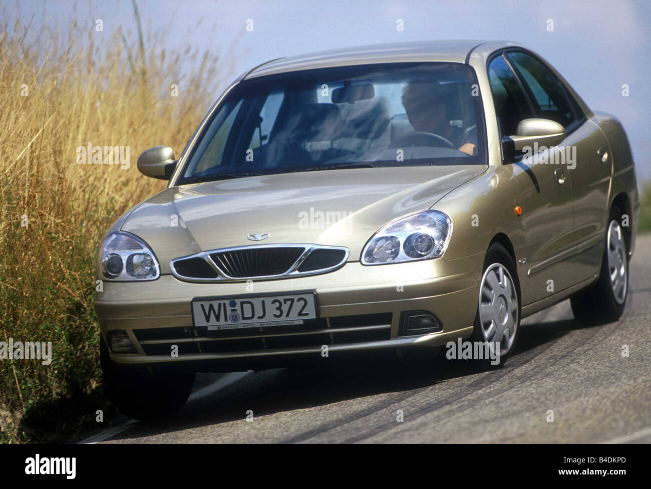 Car, Daewoo Nubira 2.0, Limousine, medium class, model year 1999-, silver-beige, fawn, diagonal from the front, driving, country Stock Photo