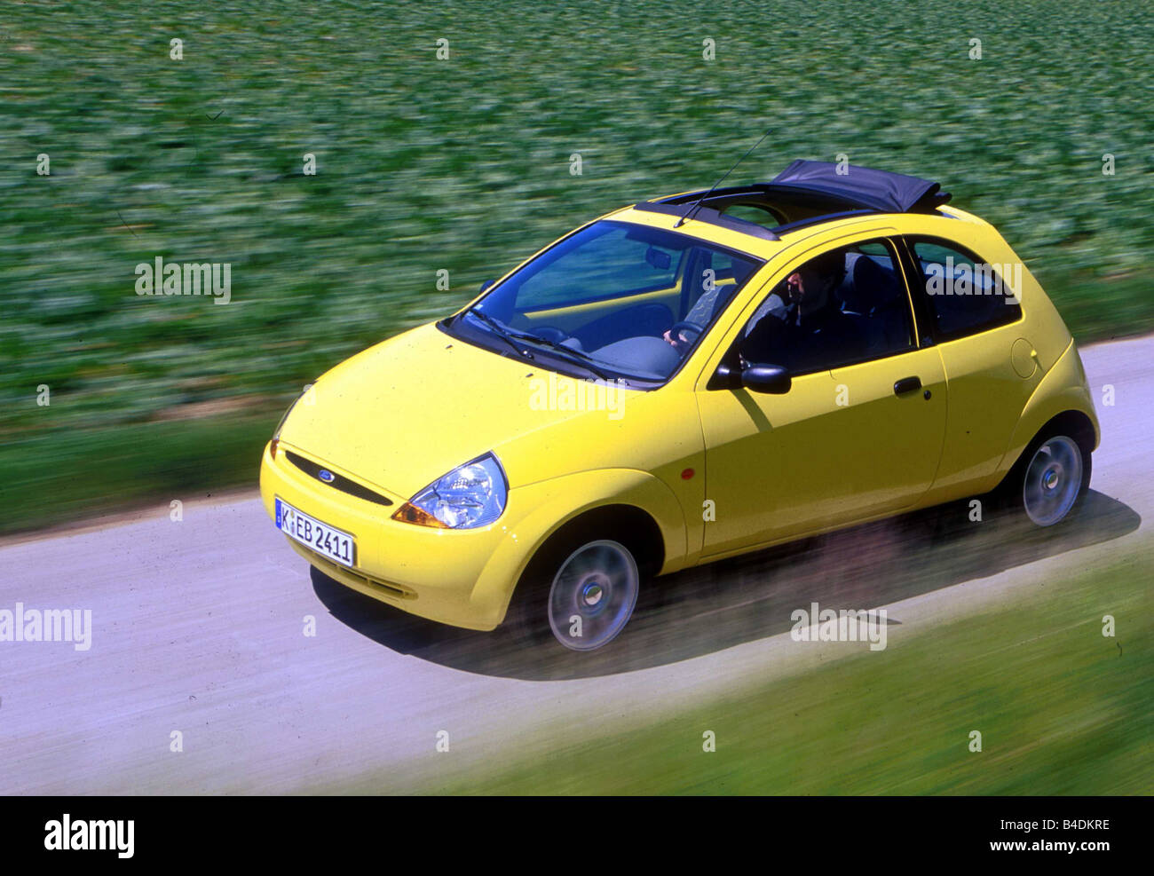 Car, Ford Ka 1.3i, small approx., Limousine, model year 1996-2002, yellow,  driving, diagonal from the front/oben, side view, cou Stock Photo - Alamy