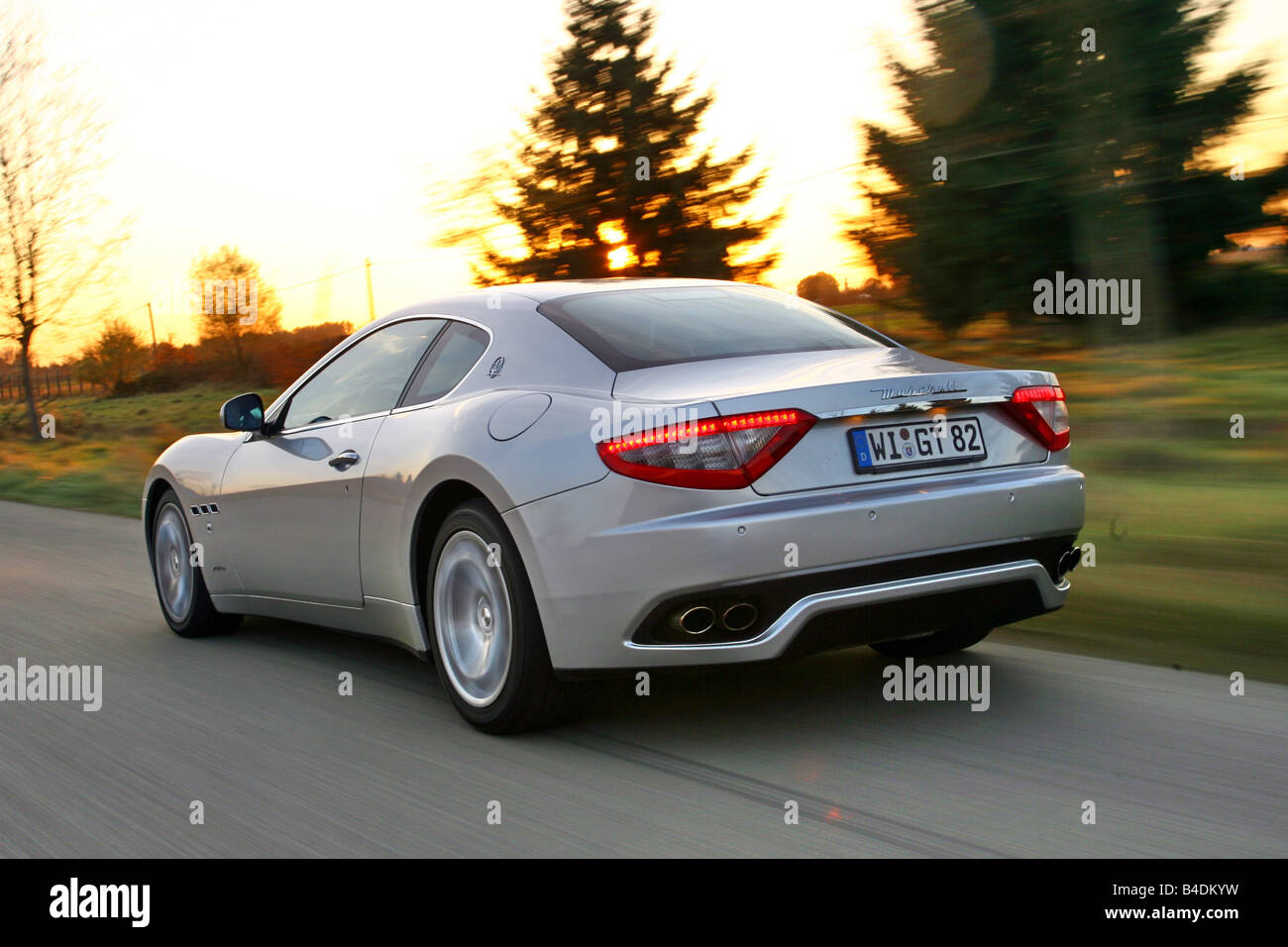 Maserati Gran Turismo, silver, model year 2007-, driving, diagonal from the back, rear view, country road Stock Photo