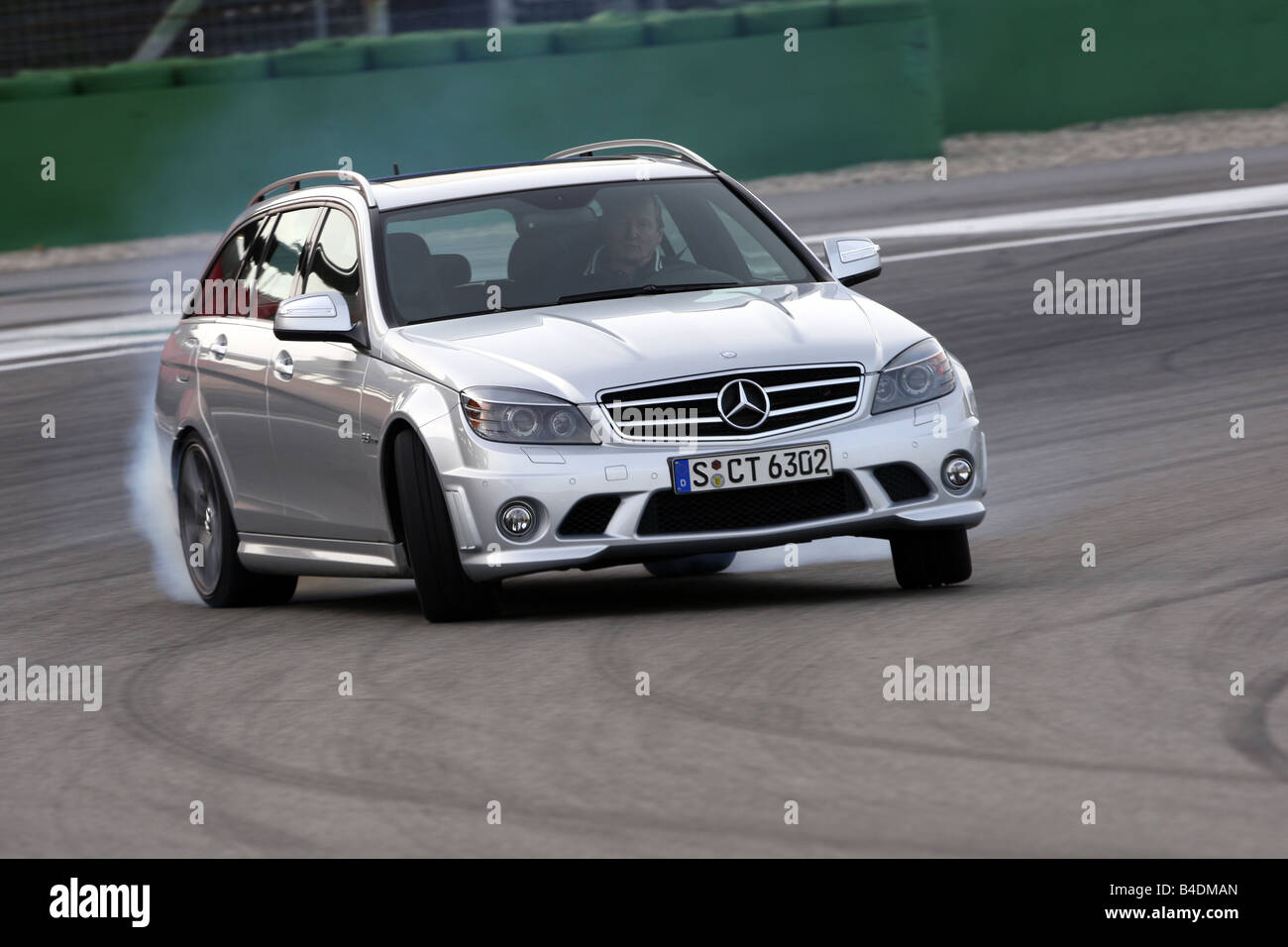 Mercedes C 63 AMG, model year 2008-, silver, driving, diagonal from the front, frontal view, test track, Drift, drifting Stock Photo