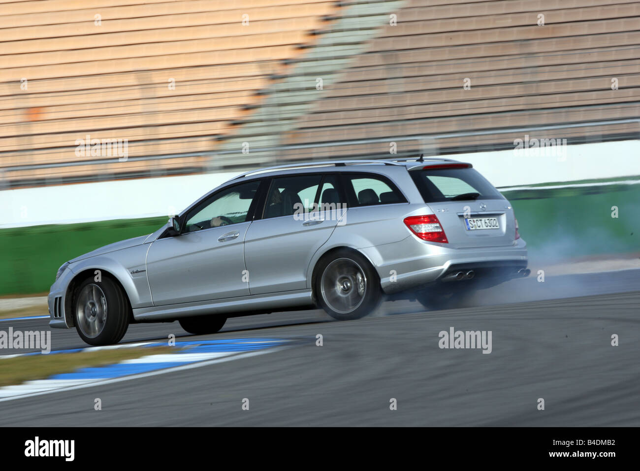 Mercedes C 63 AMG, model year 2008-, silver, driving, diagonal from the back, rear view, side view, test track, Drift, drifting Stock Photo