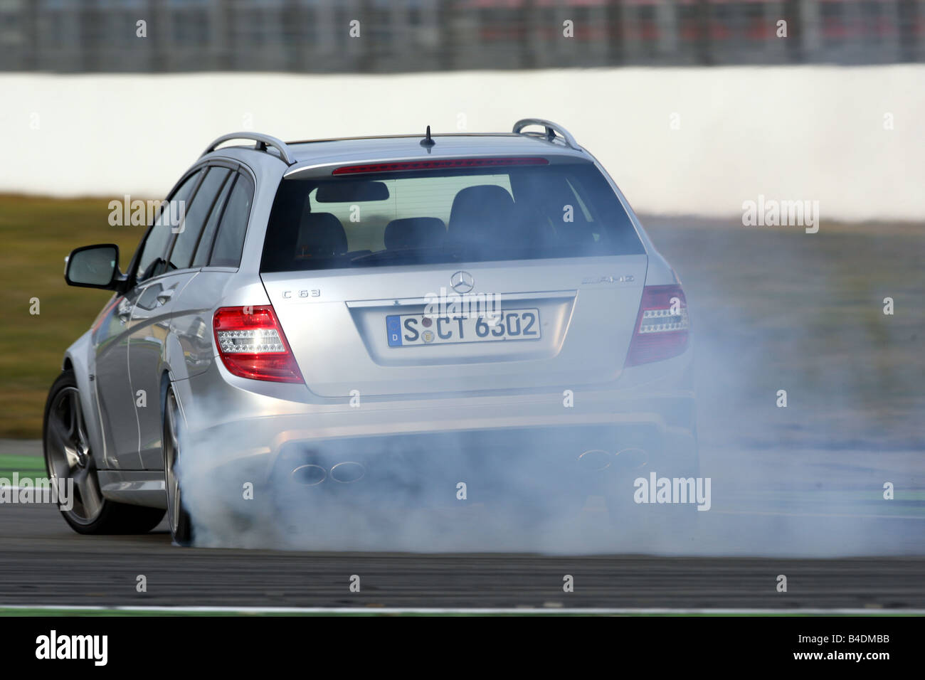 Mercedes C 63 AMG, model year 2008-, silver, driving, diagonal from the back, rear view, test track, Drift, drifting Stock Photo