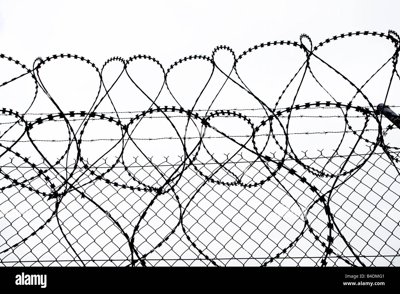Razor wire and fence silhouette UK Stock Photo