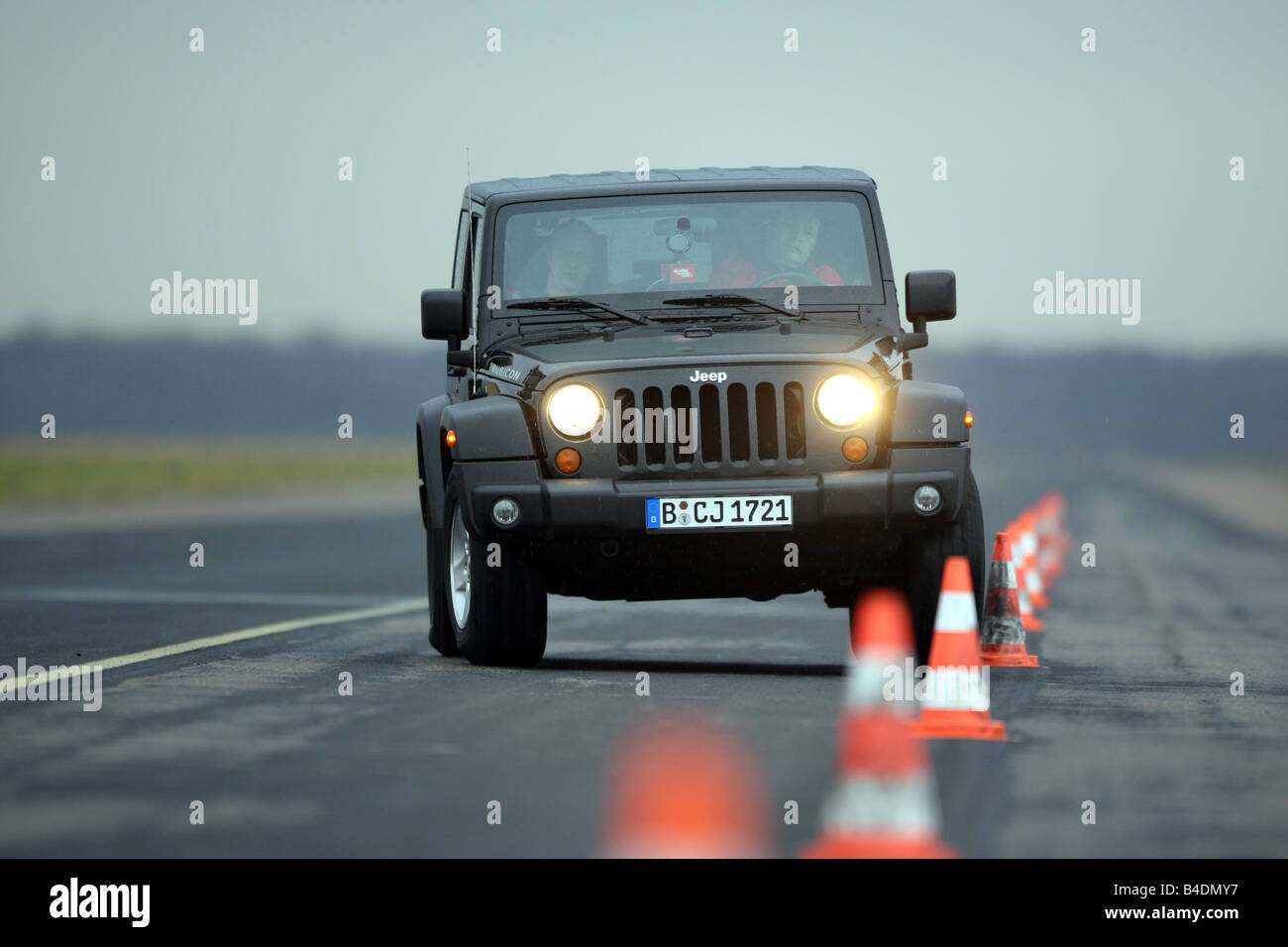 Jeep Wrangler Rubicon 3.8, model year 2008-, black, driving, diagonal from the front, frontal view, Pilonen, test track Stock Photo
