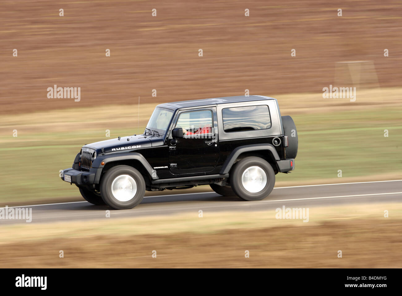 Jeep Wrangler Rubicon 3.8, model year 2008-, black, driving, side view, country road Stock Photo
