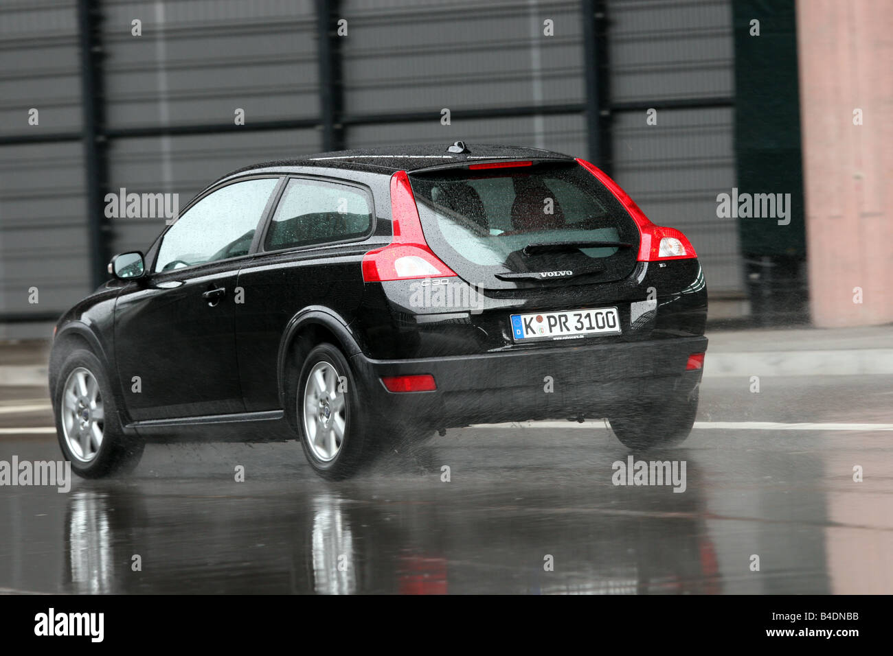 Volvo C30 1.6 Kinetic1, model year 2006-, red, driving, diagonal from the back, rear view, City Stock Photo