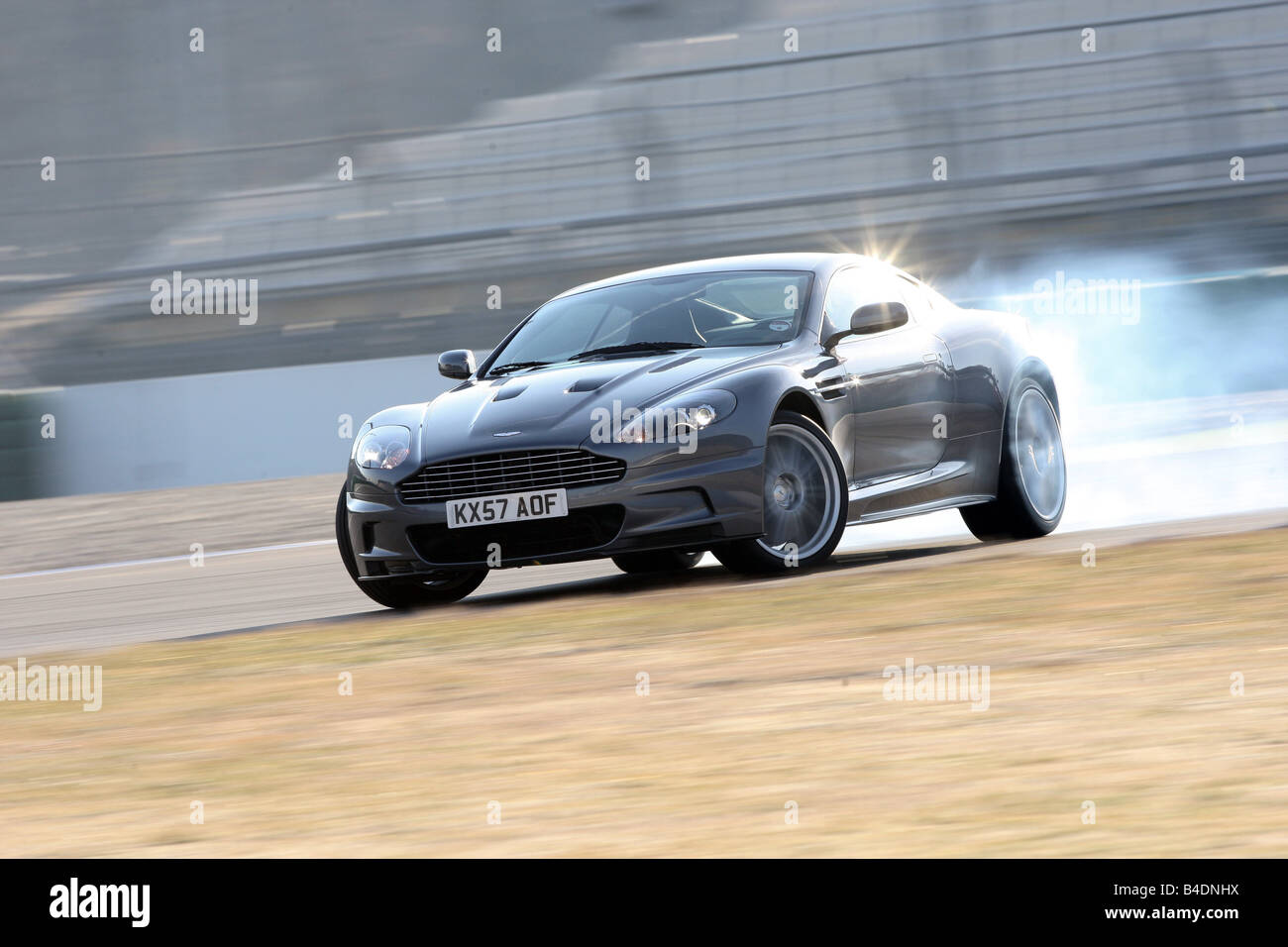 Aston Martin DBS, model year 2008-, anthracite, driving, diagonal from the front, frontal view, test track, Drift, drifting, puf Stock Photo