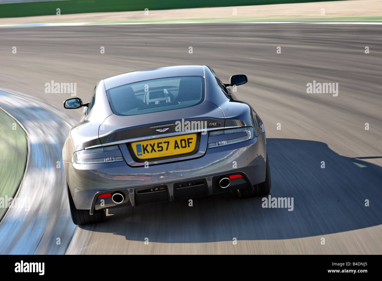 Aston Martin DBS, model year 2008-, anthracite, driving, diagonal from the back, rear view, test track Stock Photo