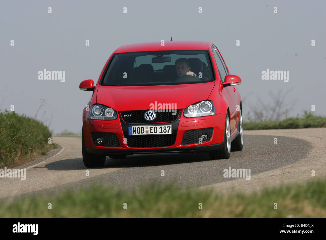 VW Volkswagen Golf GTI, model year 2004-, red, driving, diagonal from the front, frontal view, country road Stock Photo