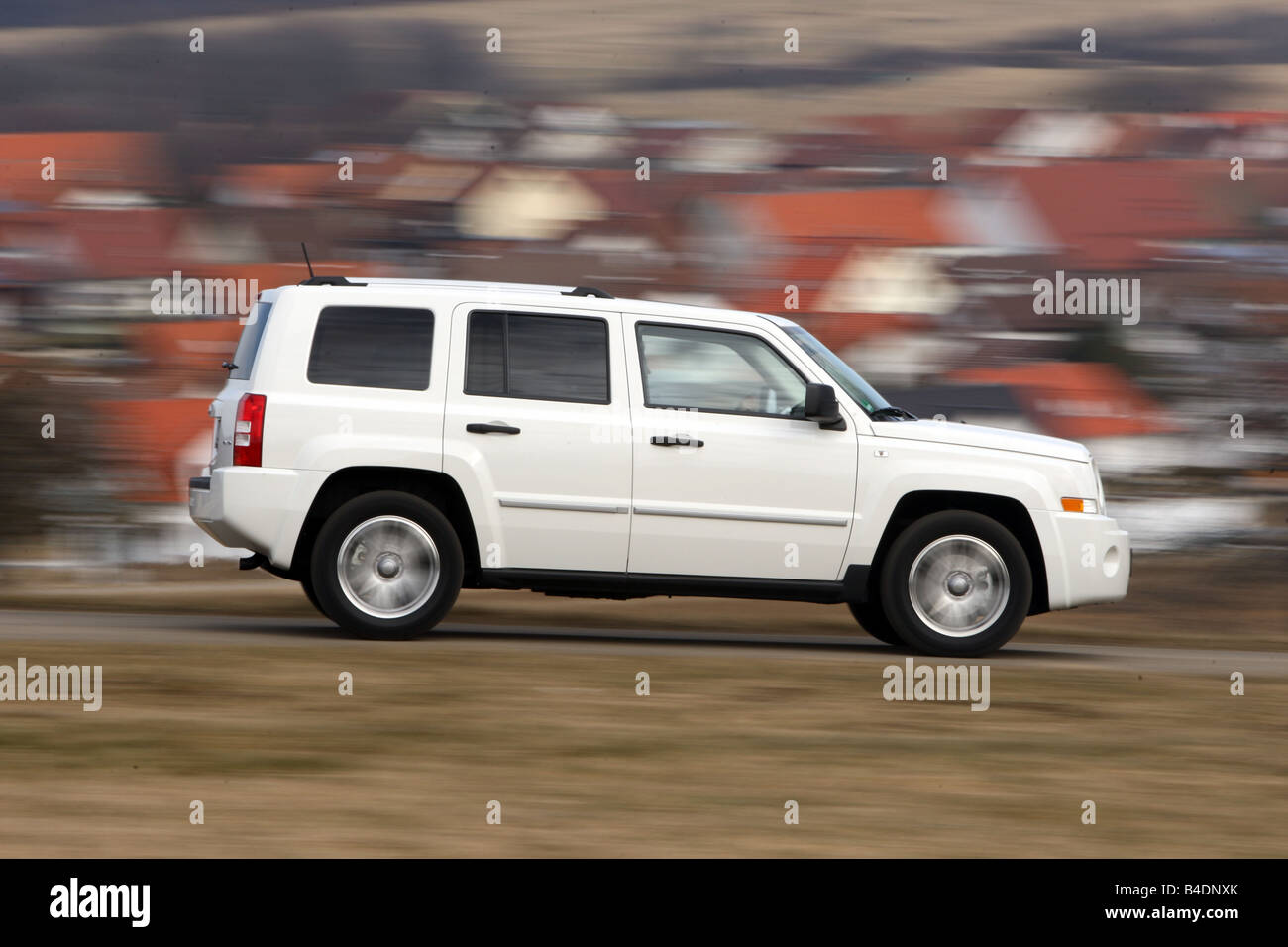 Jeep Patriot, model year 2008-, white, driving, side view, country road Stock Photo