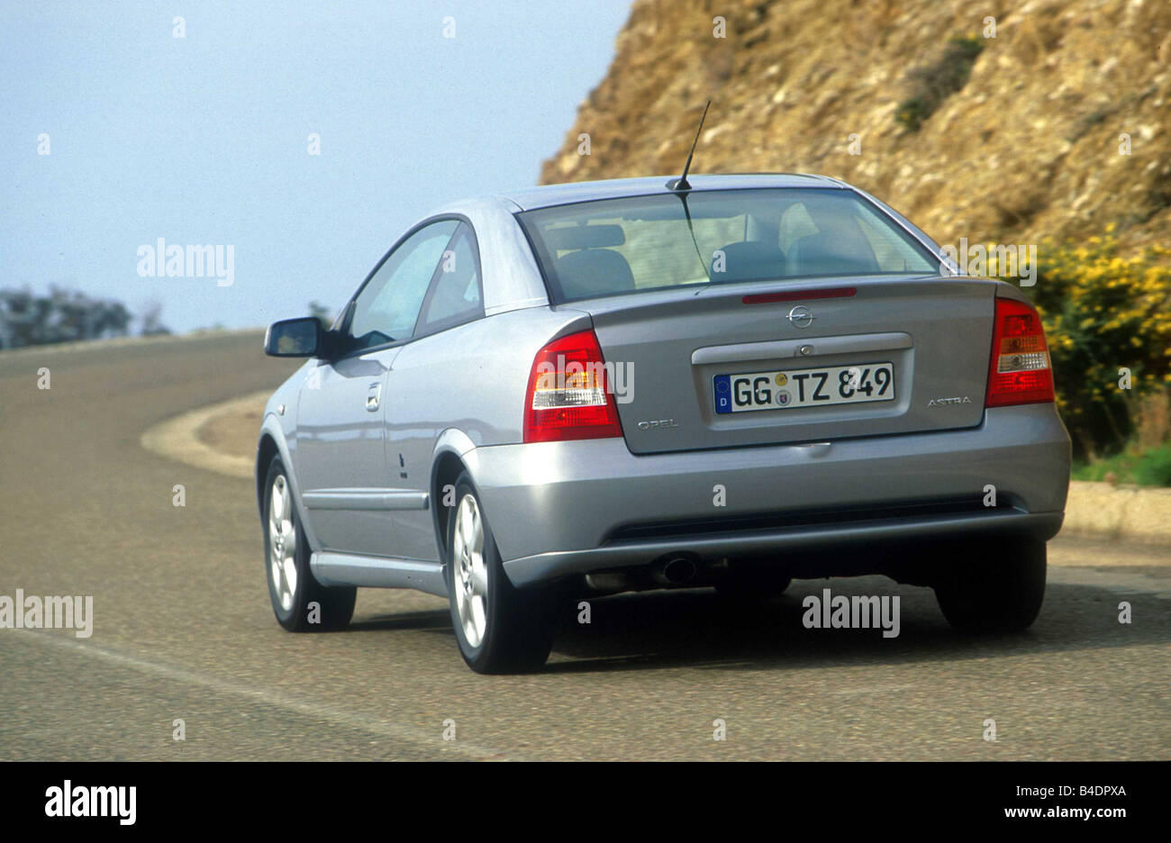 Car, Opel Astra coupe 2.2 16V, Lower middle-sized class, model year 2000-,  silver, diagonal from the back, driving, country road Stock Photo - Alamy