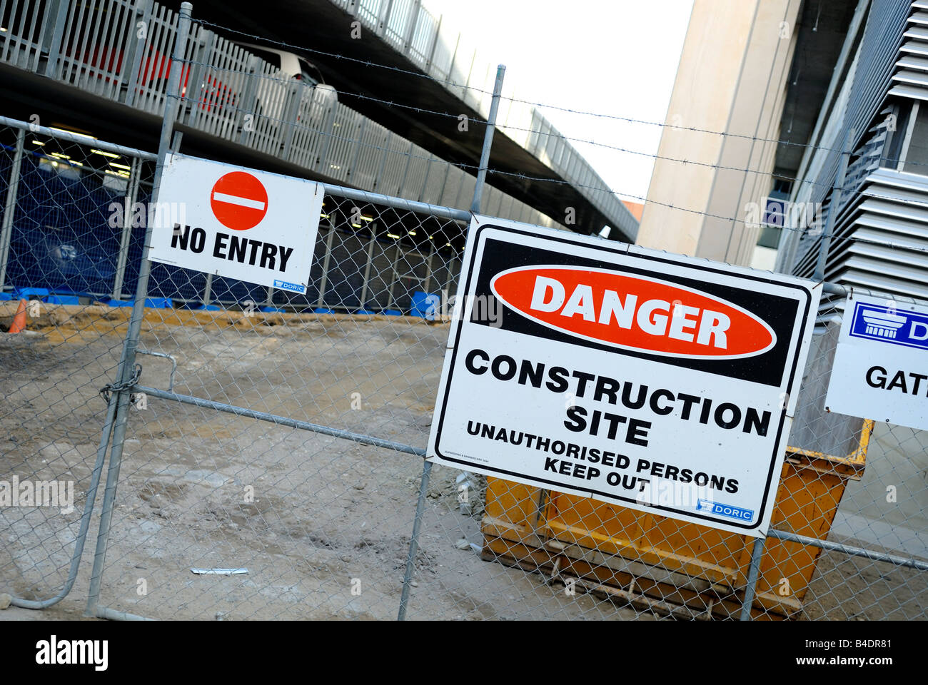 "No Entry" and "Danger" signs on gate of construction site Stock Photo