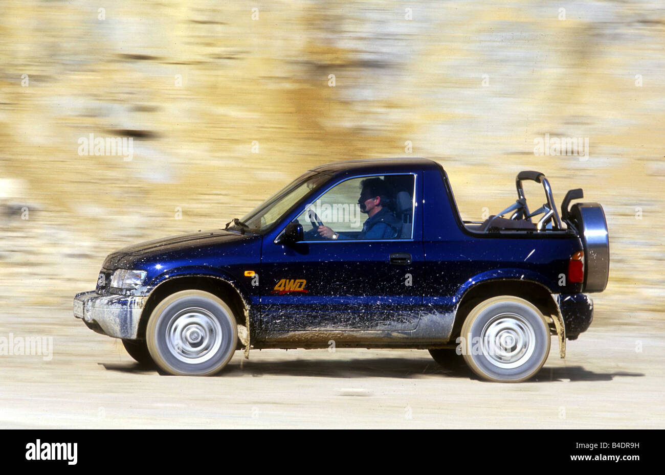 Car, KIA Sportage, cross country vehicle, model year 2000-, blue, side  view, driving, offroad Stock Photo - Alamy