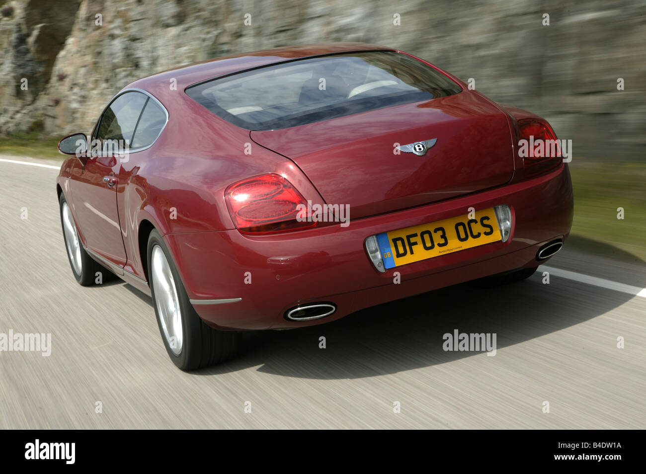 Car, Bentley Continental GT, model year 2003-, Coupe, Luxury approx.s, ruby colored, driving, country road, diagonal from the ba Stock Photo