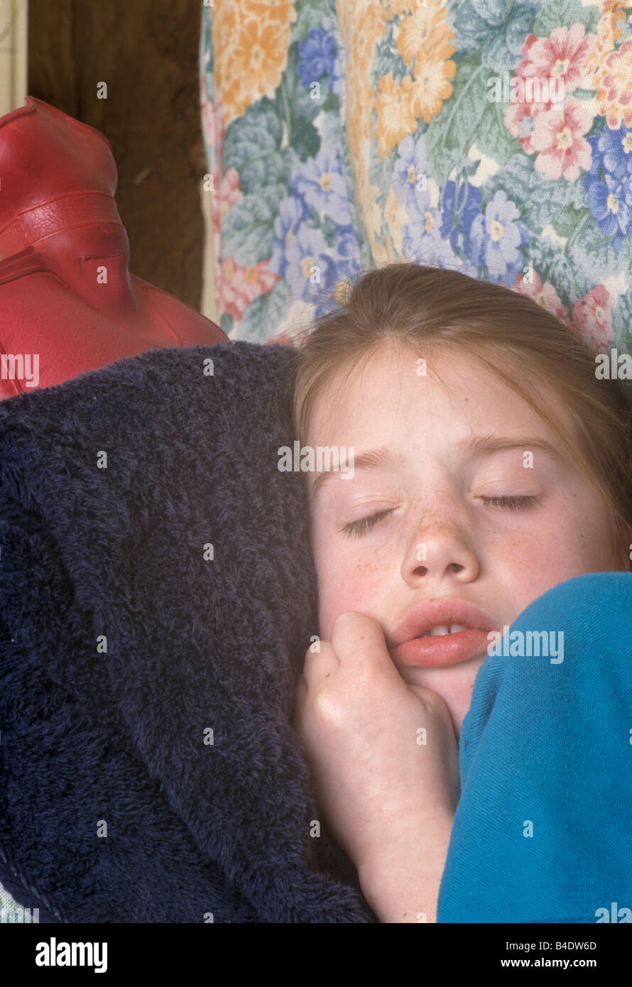 little girl with earache curled up with a hot water bottle against her ear  Stock Photo - Alamy