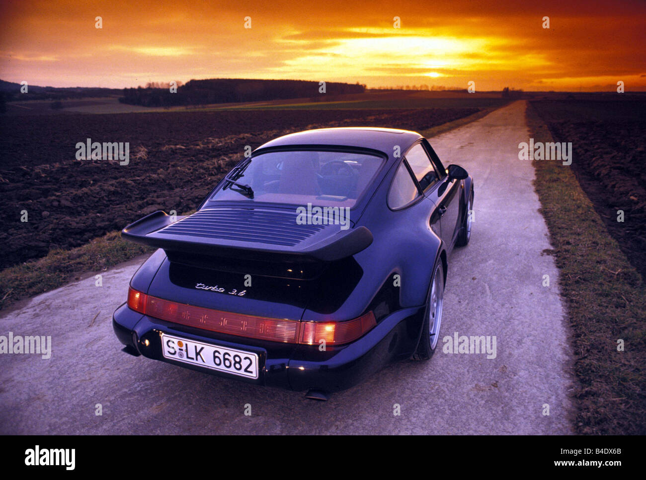 Car, Porsche Turbo 3.6, model year 1976, roadster, coupe, black, diagonal from the back, rear view, country road, Sunset, landsa Stock Photo