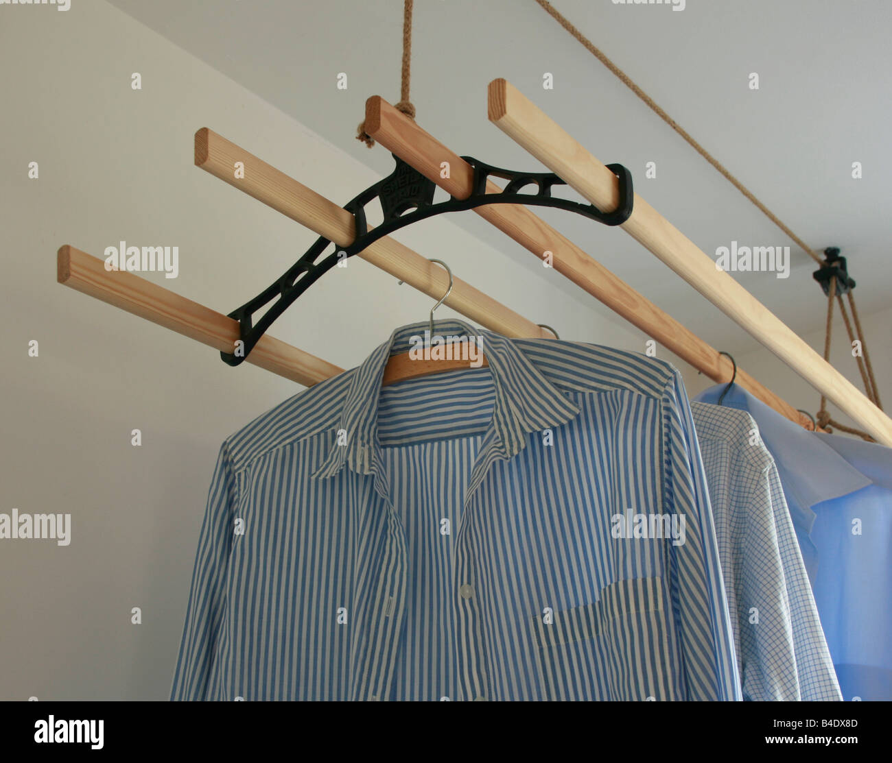 Shirts hung up to dry indoors on a ceiling rack - energy saving ! Stock Photo