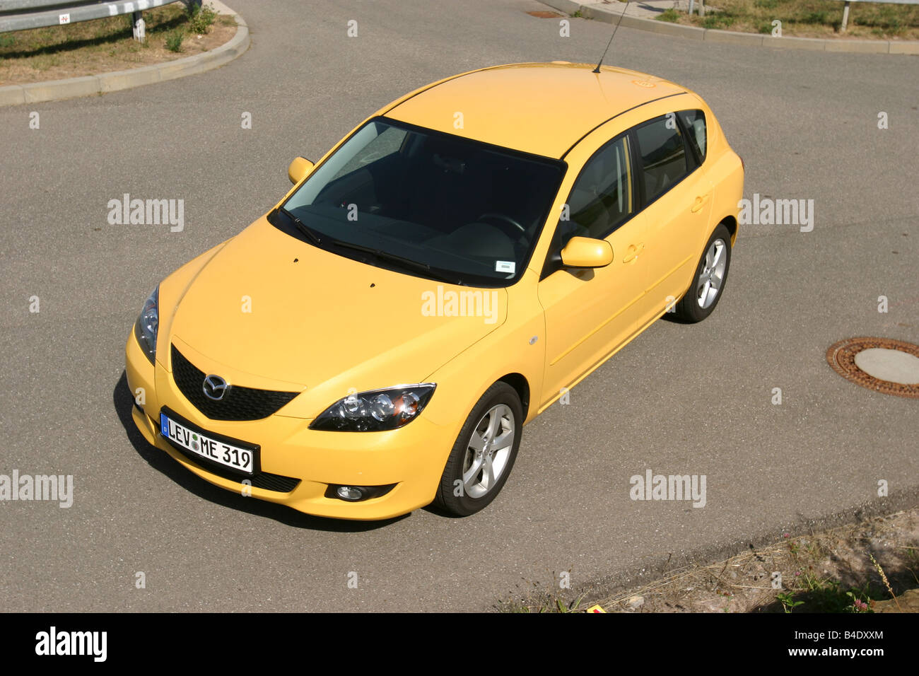Car, Mazda 3 Sport 1.6, Lower middle-sized class, Limousine, model year 2003-, FGHDS, yellow, standing, upholding, diagonal from Stock Photo