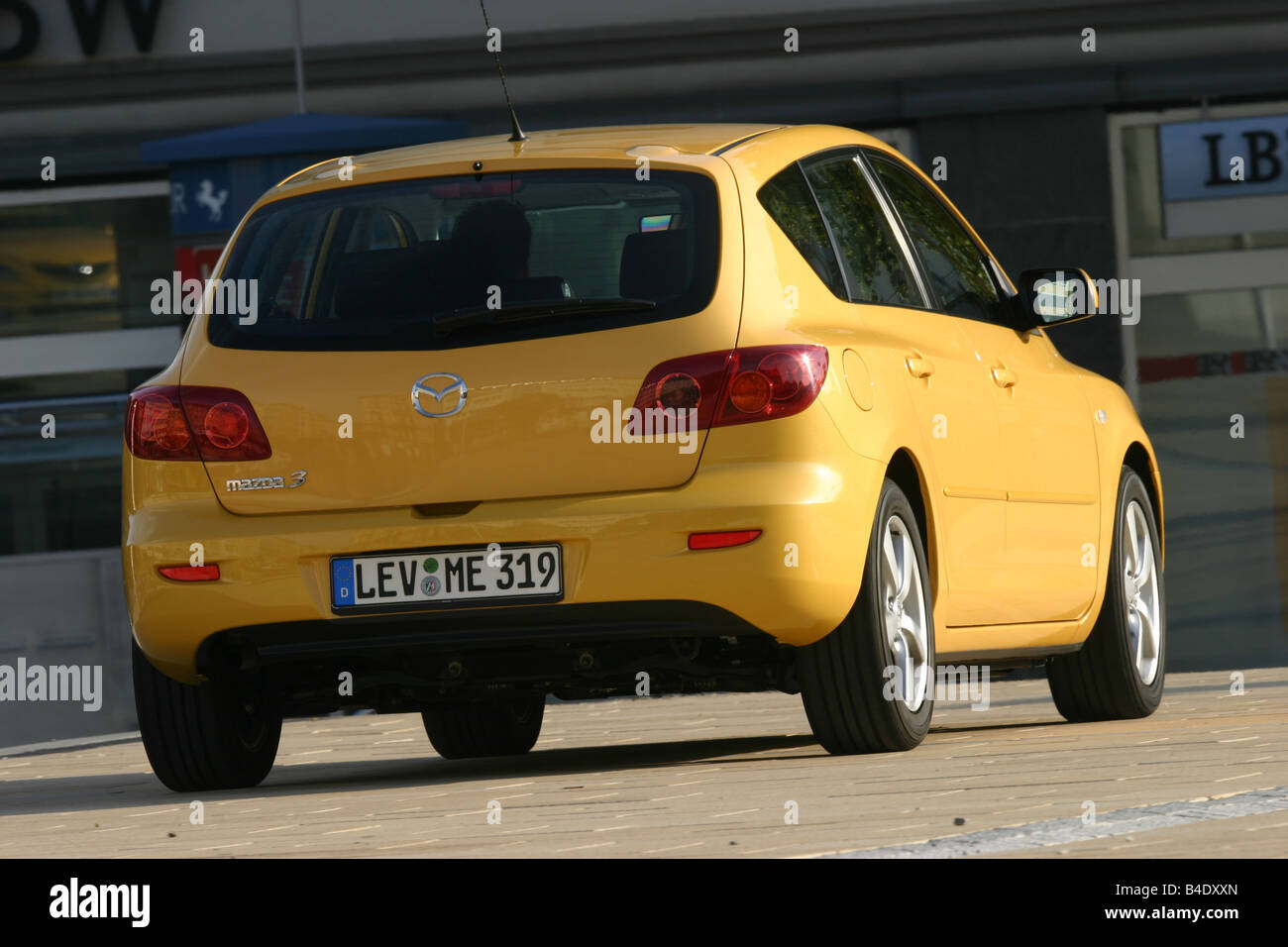 Car, Mazda 3 Sport 1.6, Lower middle-sized class, Limousine, model year 2003-, FGHDS, yellow, diagonal from the back, rear view, Stock Photo