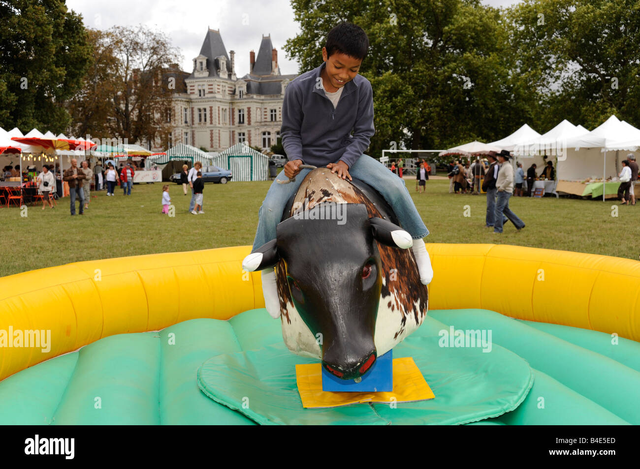 boy playing with mechanical bull Fondettes Touraine France Stock Photo