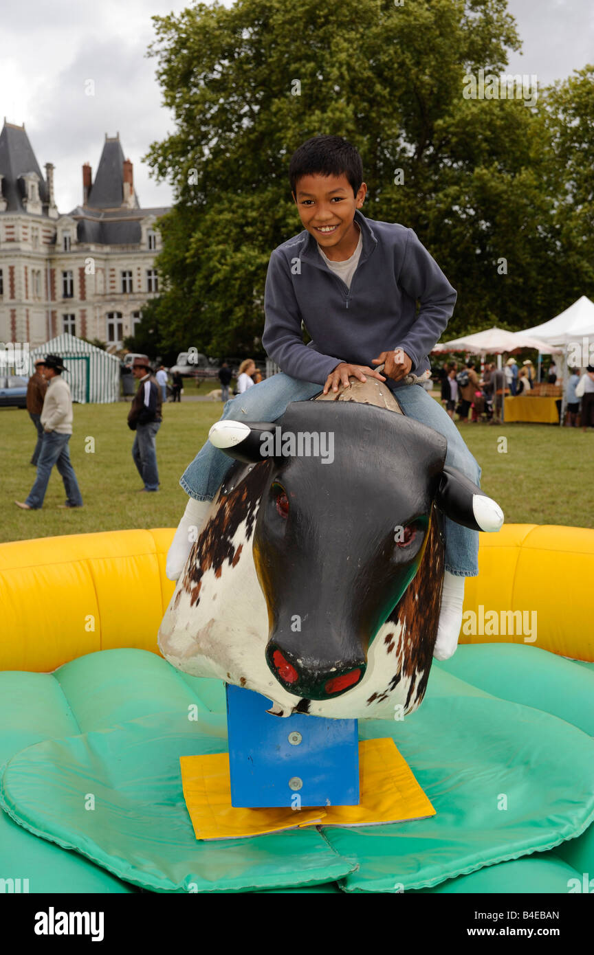 boy playing with mechanical bull Fondettes Touraine France Stock Photo