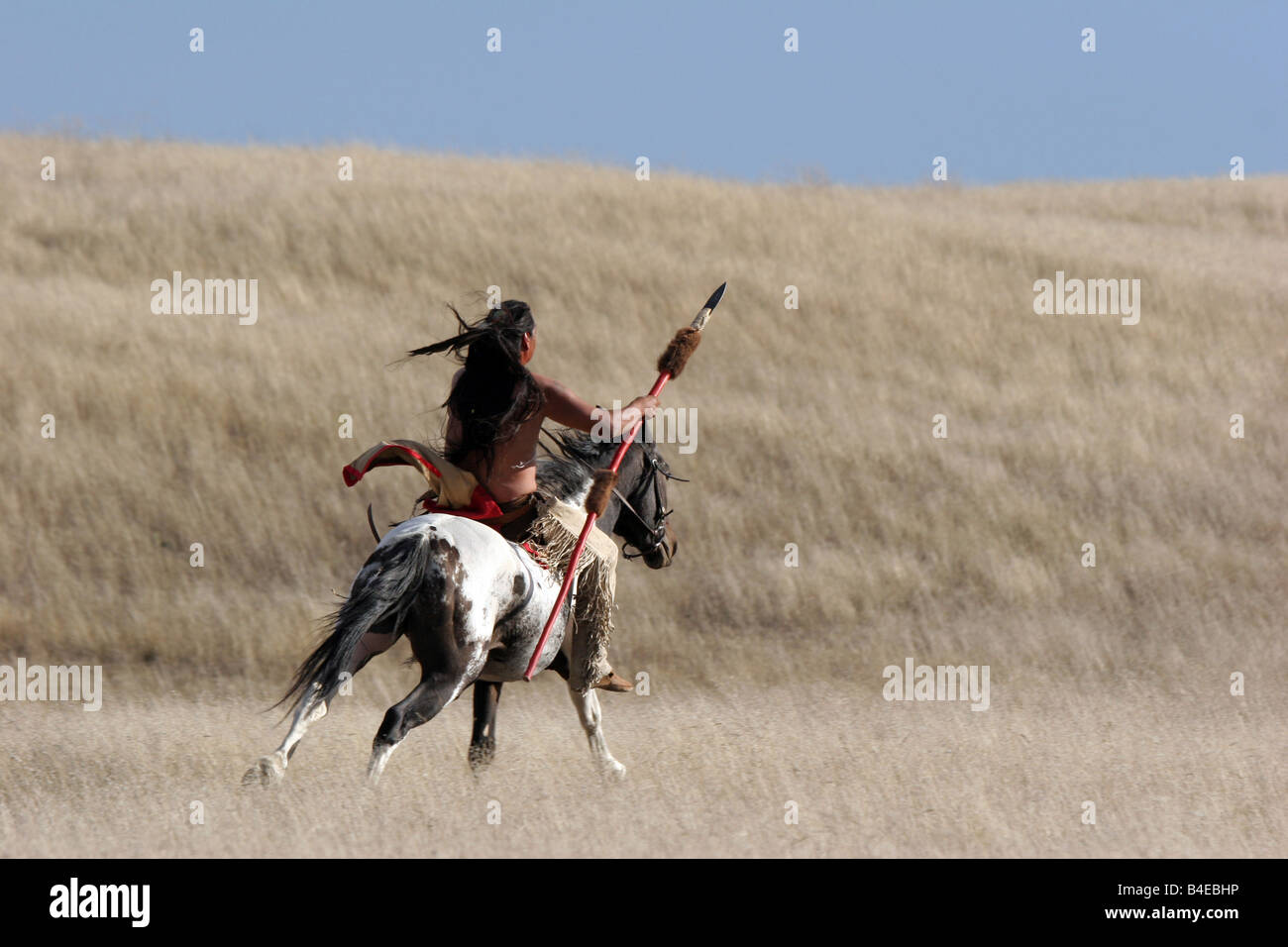 A Native American Indian with a spear riding horseback in South Dakota