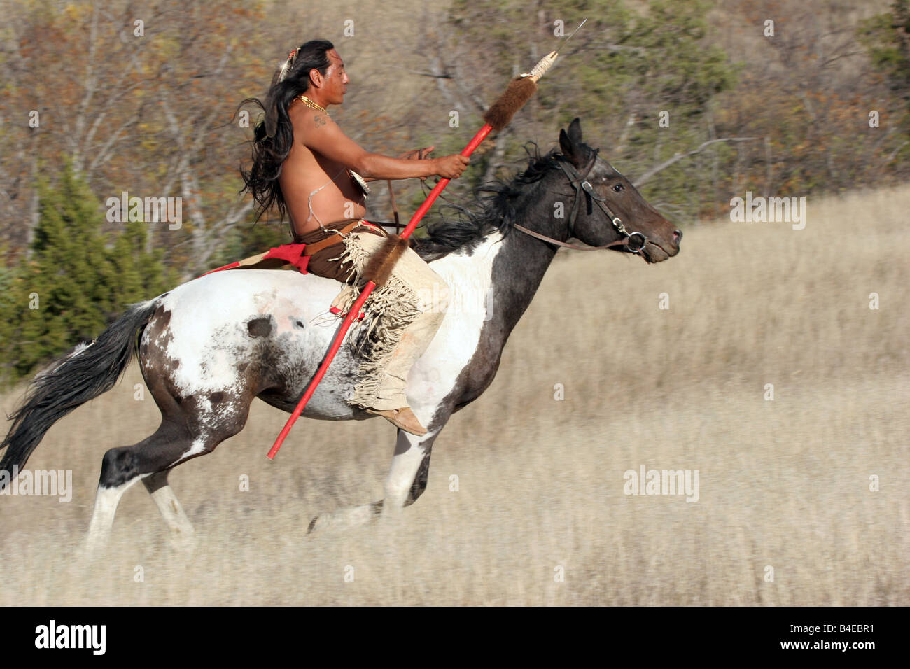 A Native American Indian with a spear riding horseback in South Dakota