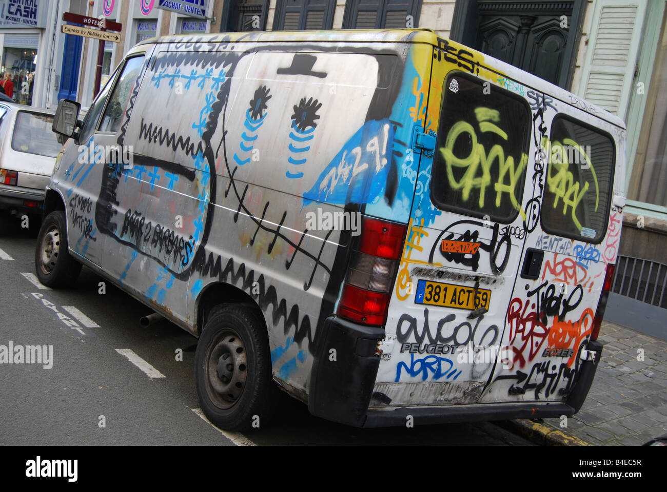 Urban street scene with vandalised graffiti covered minivan parked along  the road in Lille France Stock Photo - Alamy