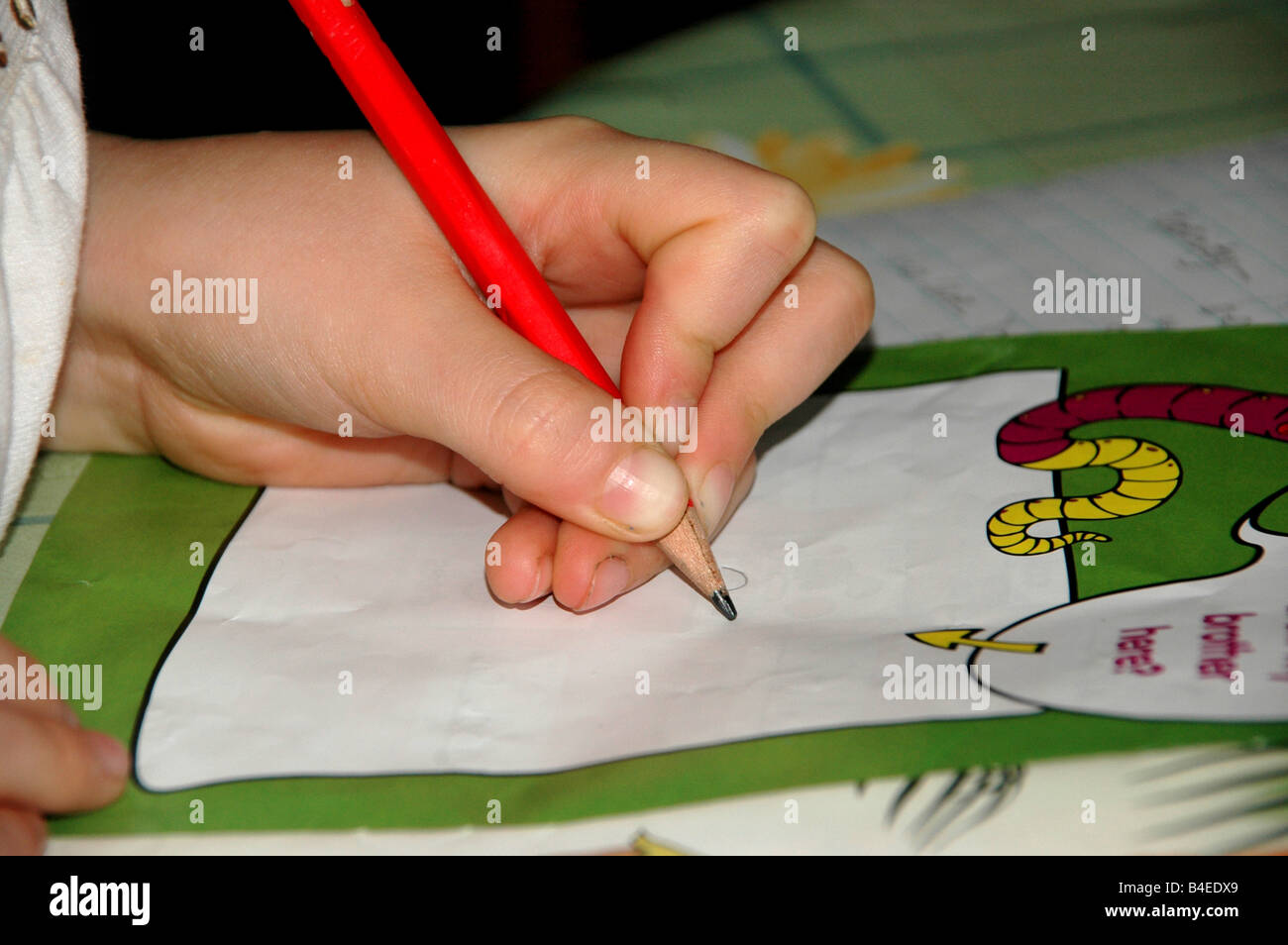 A young girl with pencil in hand begins to draw a picture in an art activity book. Stock Photo