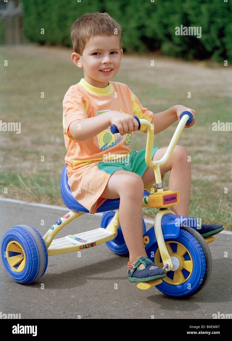 Child riding a trike Stock Photo Alamy