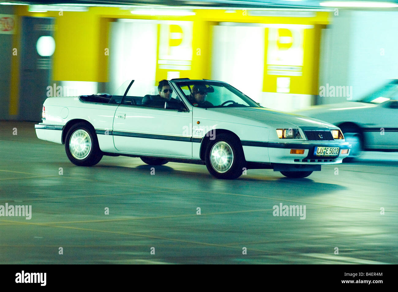 Car, Chrysler Lebaron convertible, model year 1986-1995, white, old car, 1980s, eighties, driving, side view, parking garage, co Stock Photo