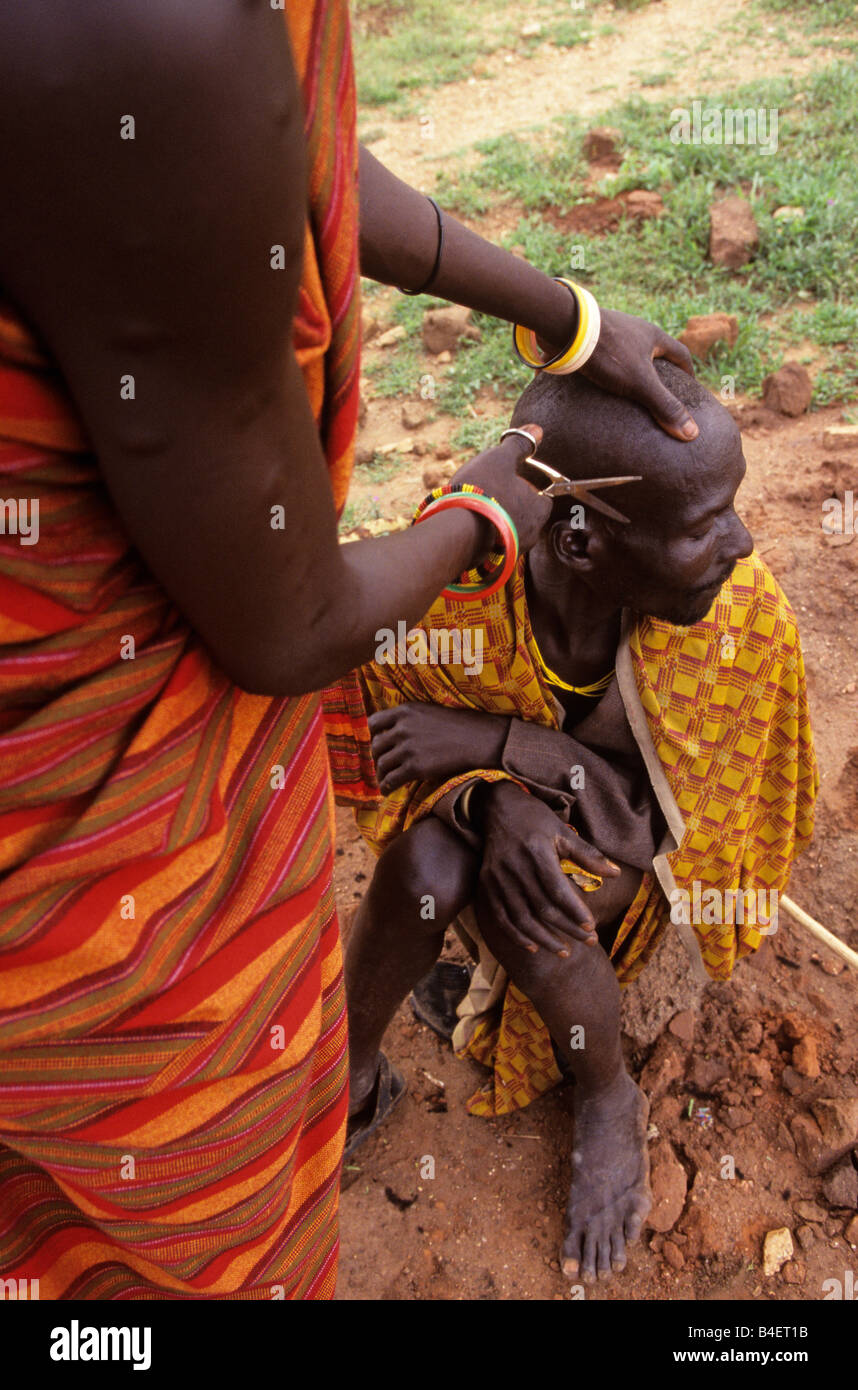 Ethnic Karamojong villager getting haircut, Karamoja, Uganda Stock Photo