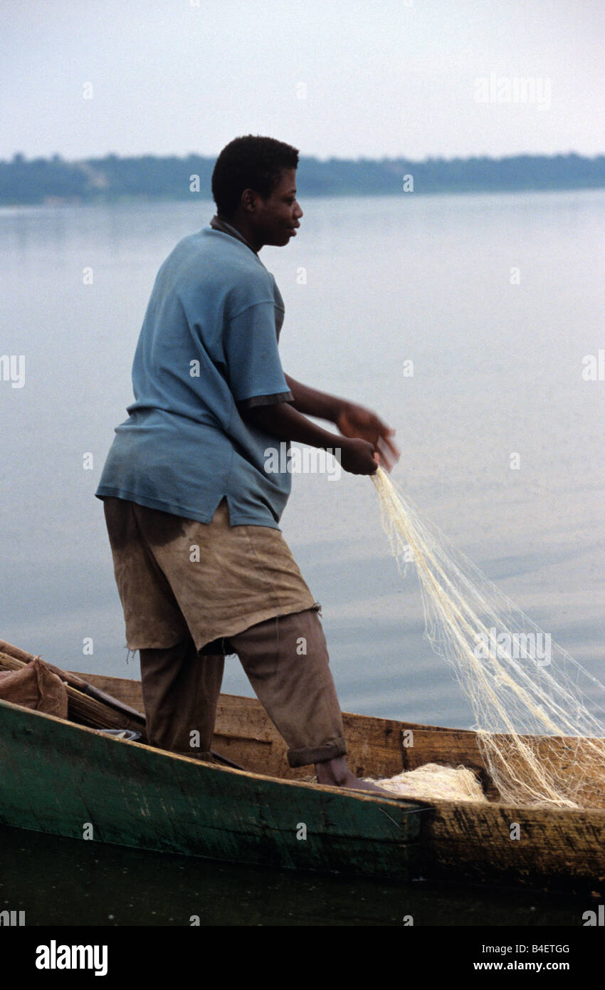 Fisherman on boat pulling fishing net from lake, Uganda, Africa Stock