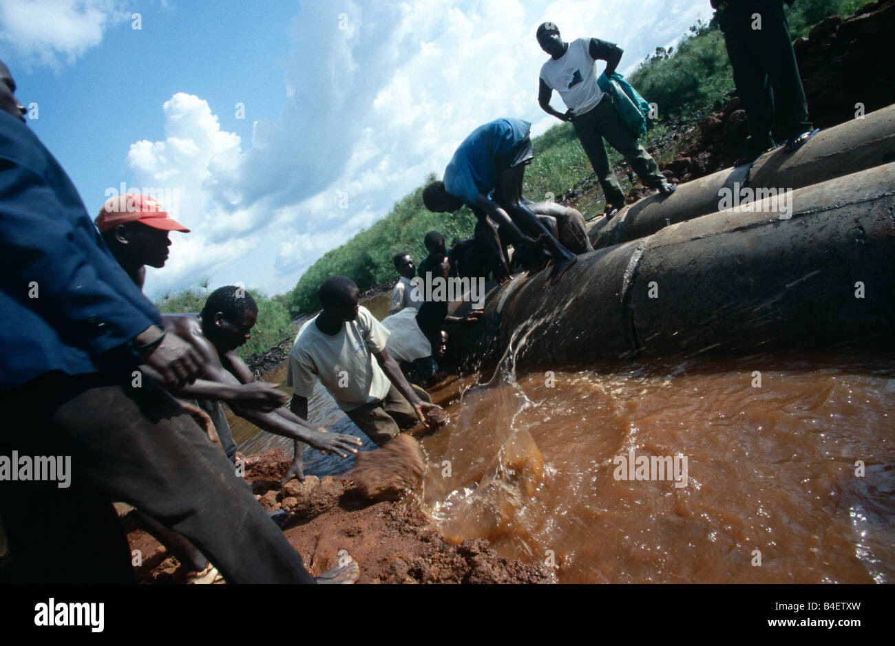 Workers repairing leaking water pipe, Uganda Stock Photo Alamy