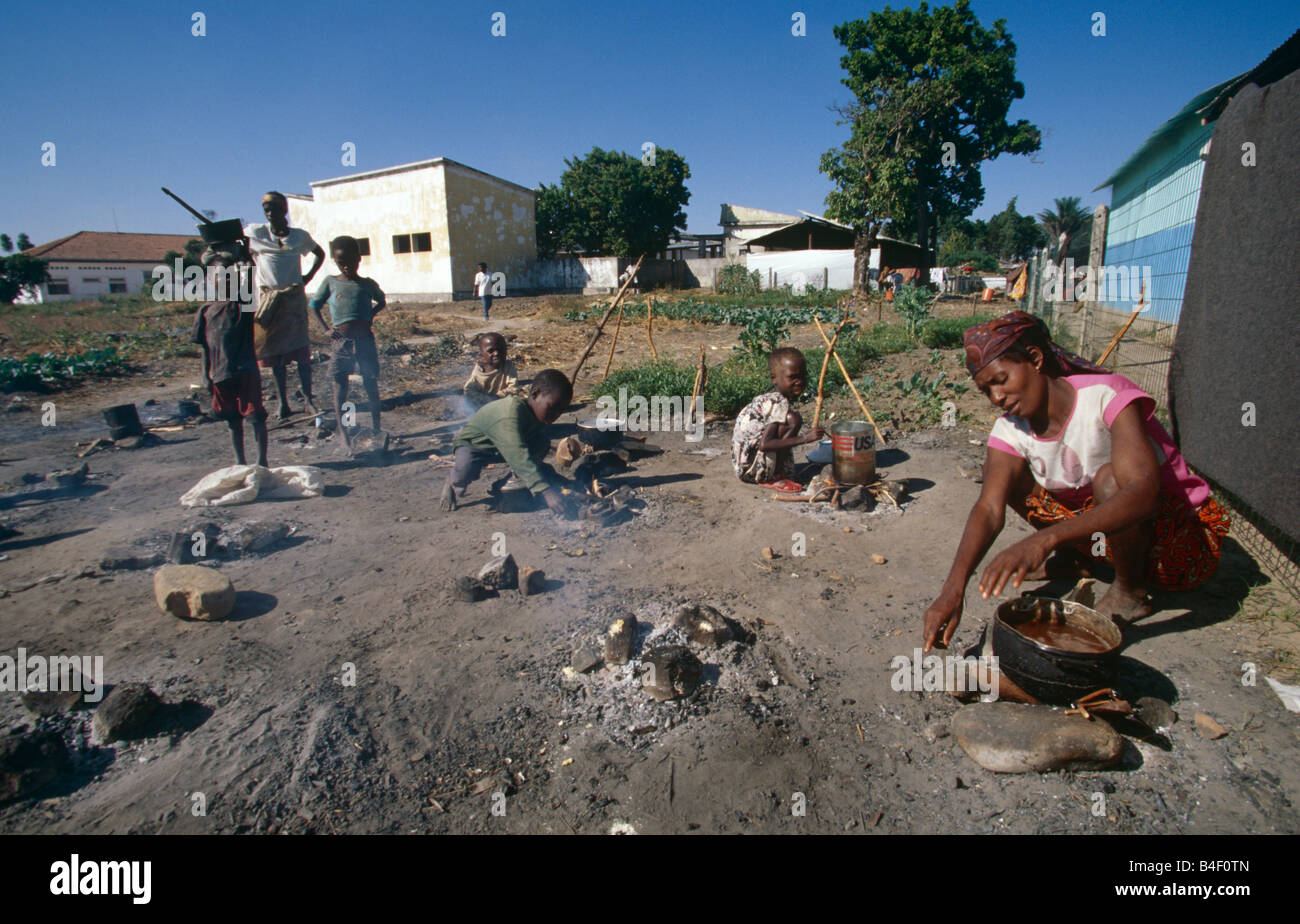 Families cooking on ground in displaced persons camp, Angola Stock Photo
