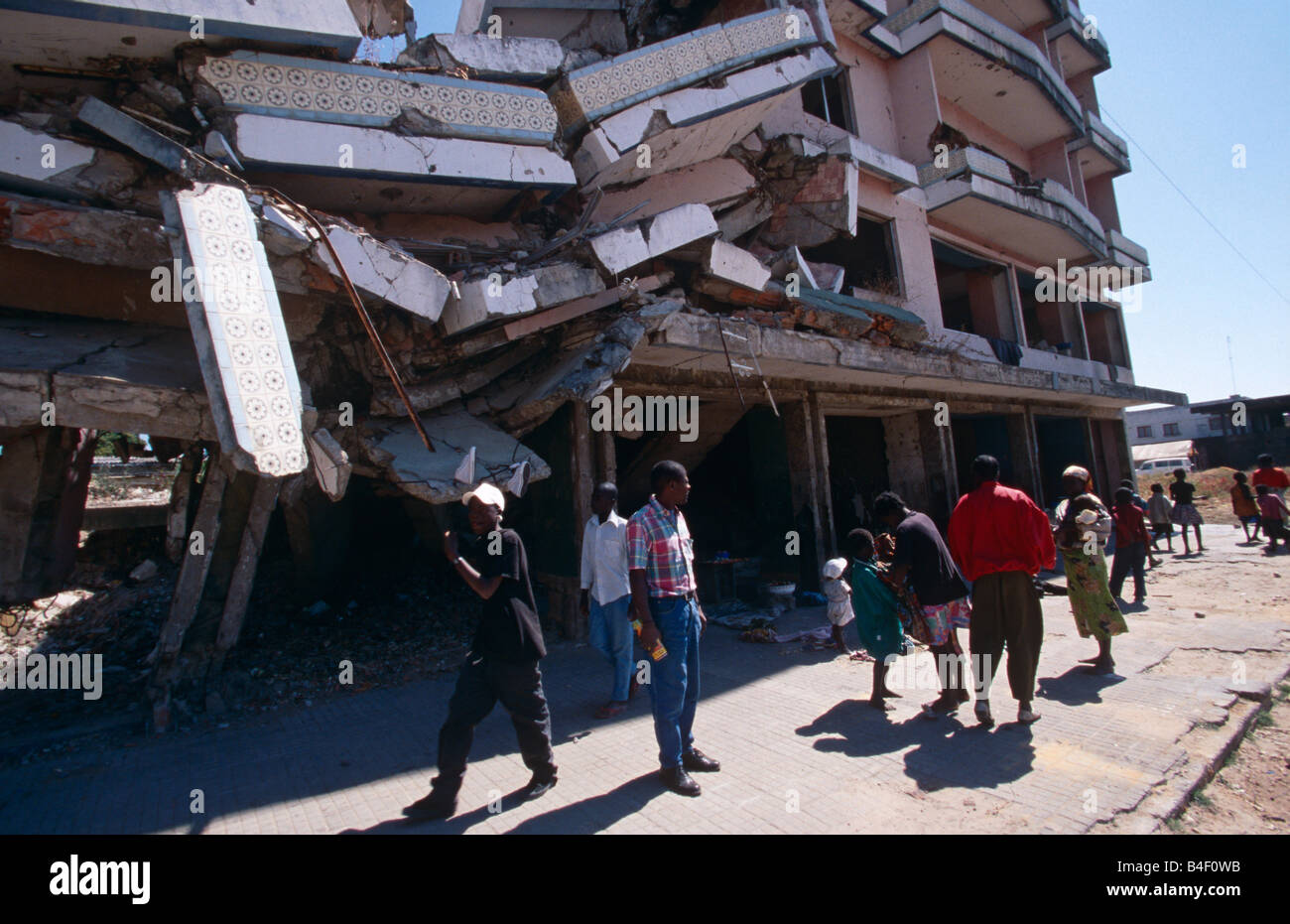 People displaced by war standing by tumbling building in war-torn Angola Stock Photo