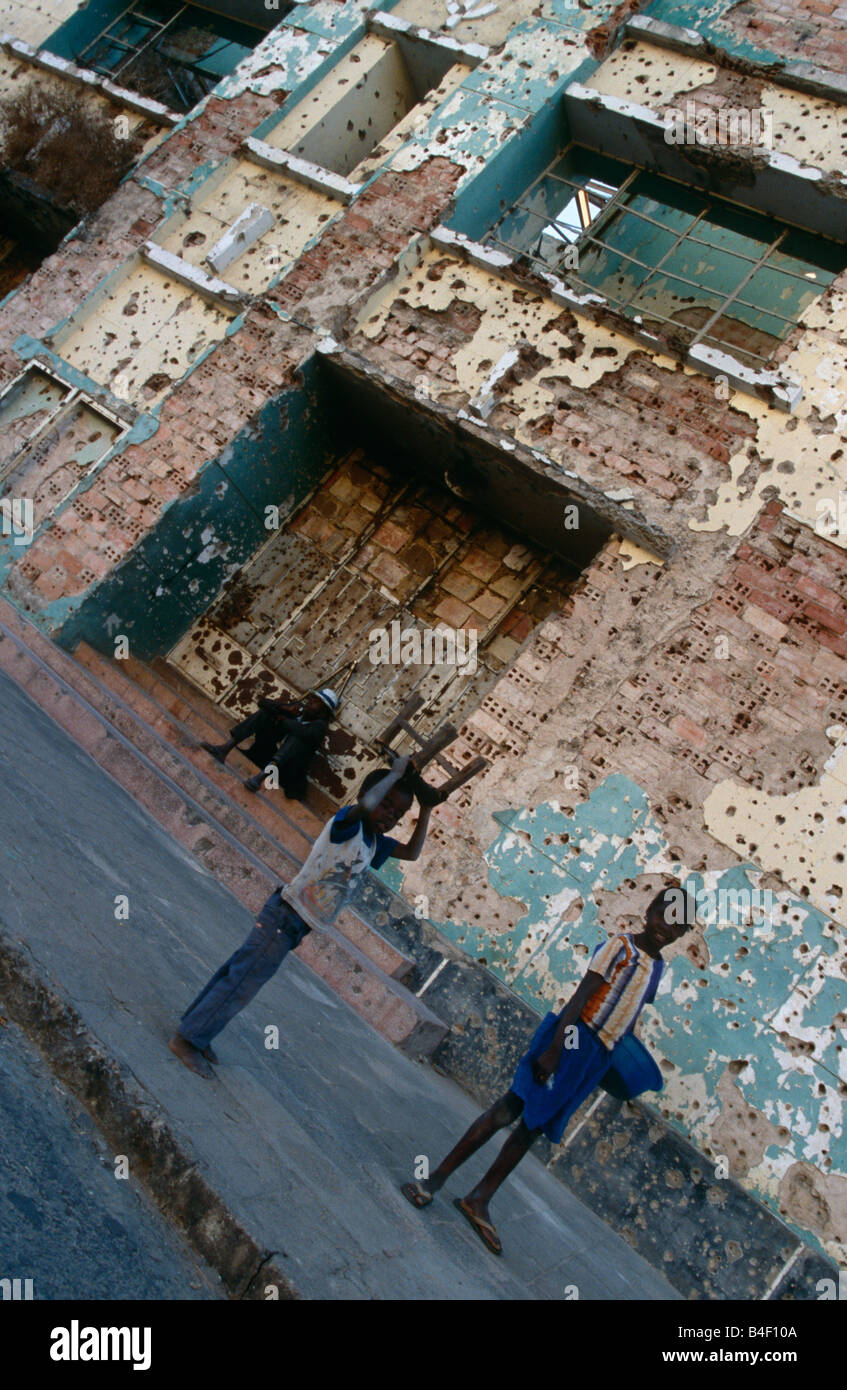 Displaced persons by bullet-riddled building, Angola Stock Photo