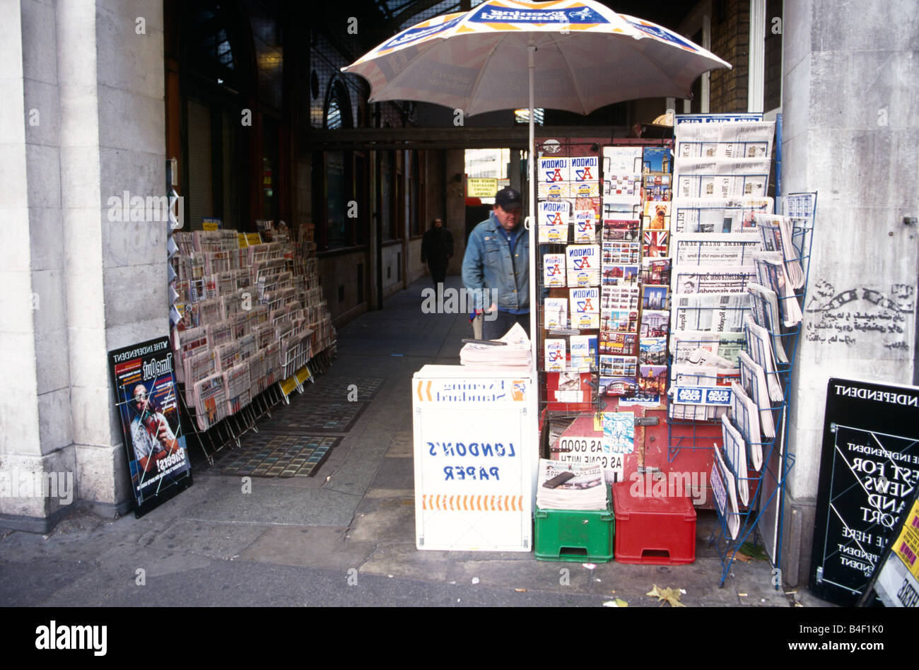 Man at newsstand in walkway, London, England, UK Stock Photo