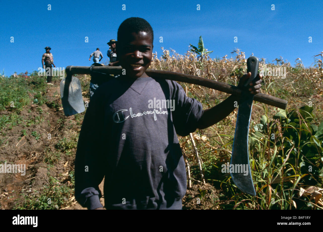 Farm workers carrying tool over his shoulder in field, portrait, Angola, Africa Stock Photo