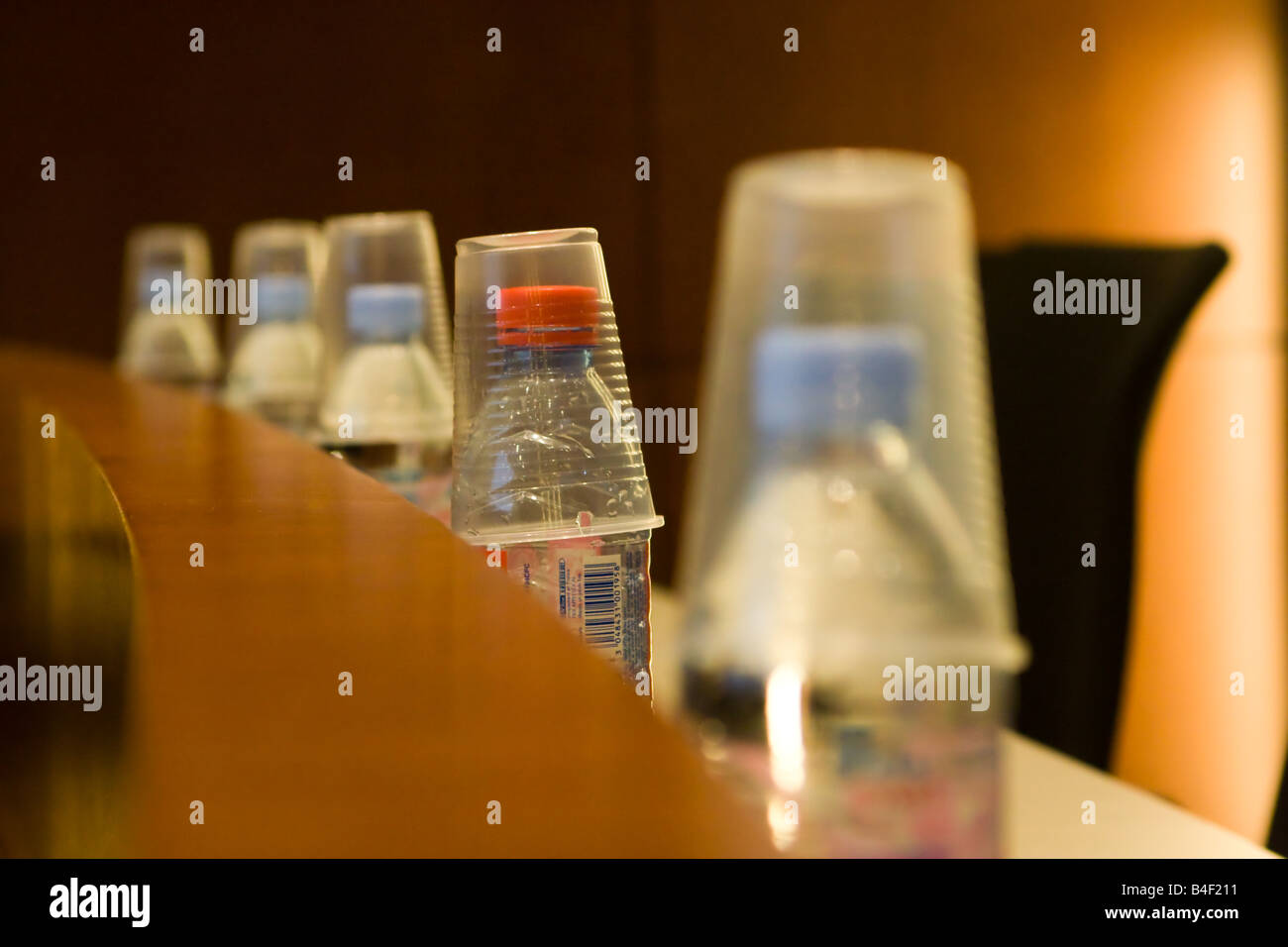 https://c8.alamy.com/comp/B4F211/a-row-of-bottled-water-bottles-and-plastic-drinking-cups-in-an-auditorium-B4F211.jpg