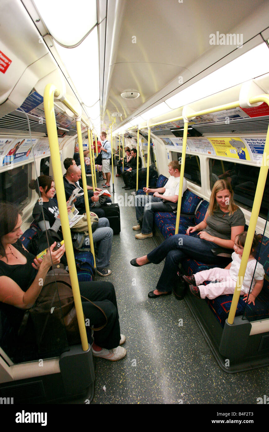 Young mother sitting next to toddler daughter riding on London underground tube train railway Stock Photo