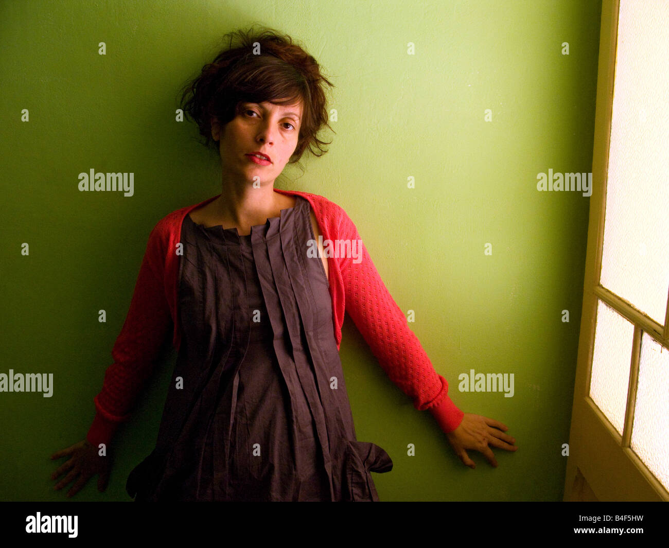 Pregnant Spanish woman standing against a green wall Stock Photo Alamy