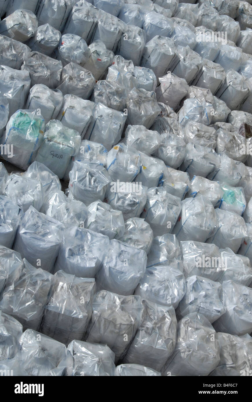 Bales of rigid plastic waste feedstock awaiting reprocessing at a plastics recycling plant Stock