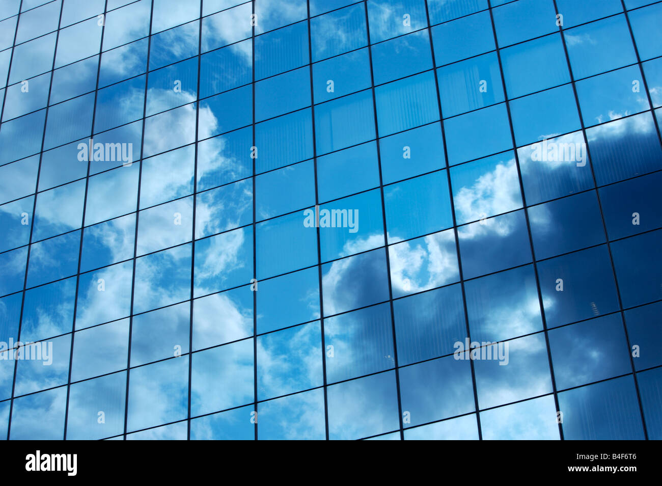 Clouds reflected in the mirrored windows of a city building Stock Photo