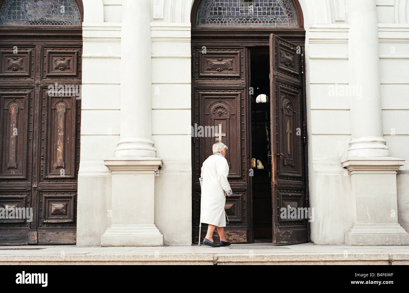 Old woman entering a church, Lodz, Poland Stock Photo